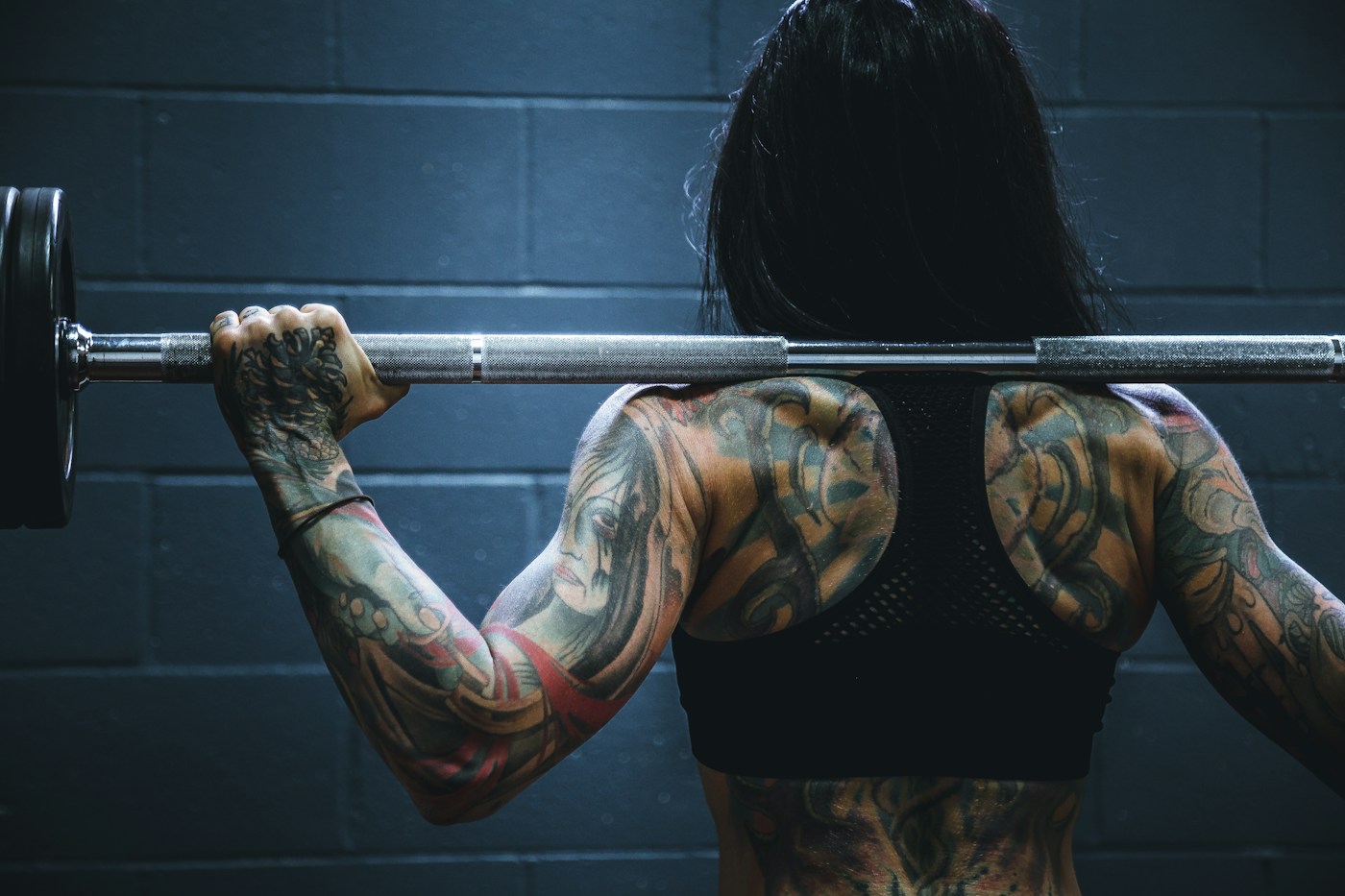 Pessoa em exercício de força em uma academia. Fotografia ilustrativa.